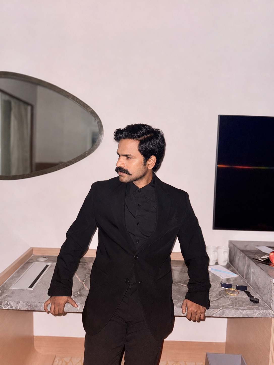 Sunkara Arjun in an all-black suit